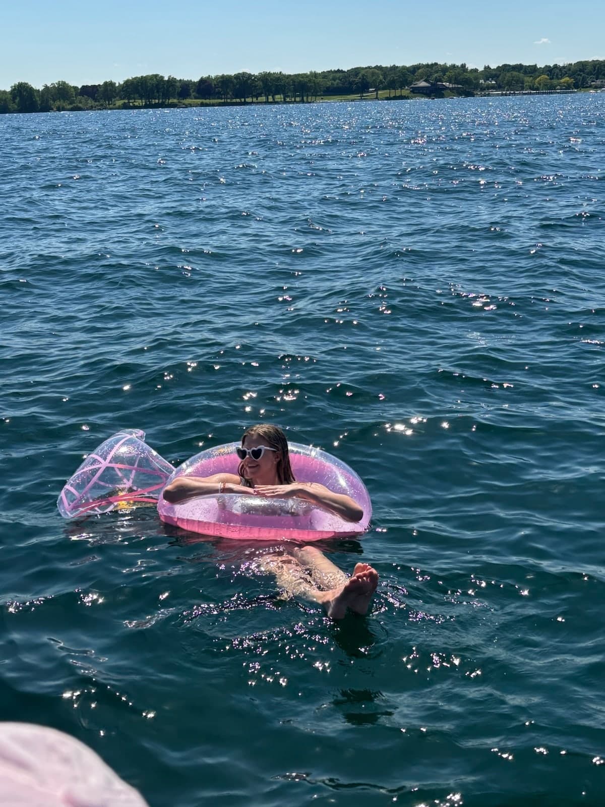 Guest relaxing on a pink float in Geneva Lake