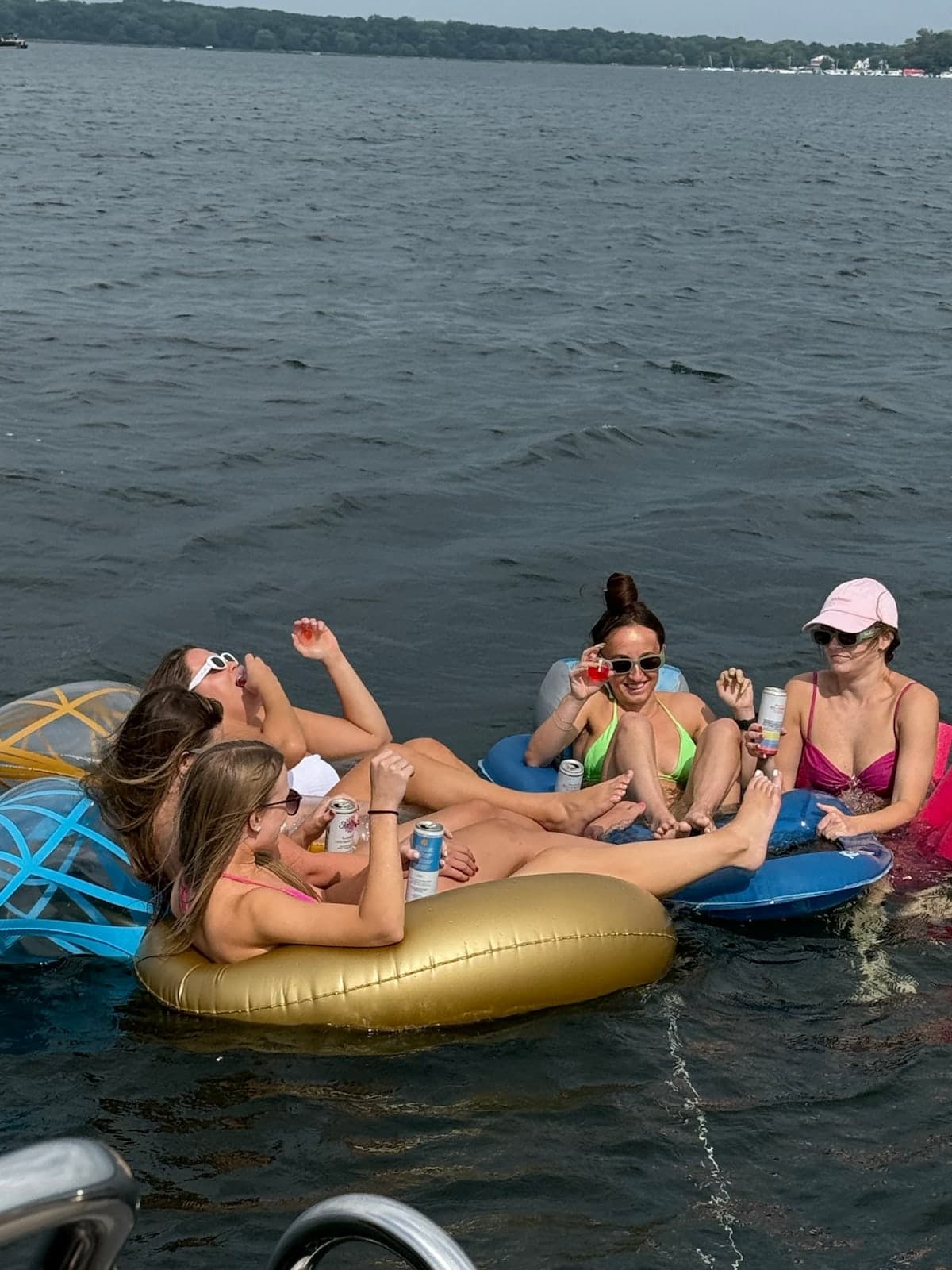 Friends sharing a toast while floating together in Geneva Lake